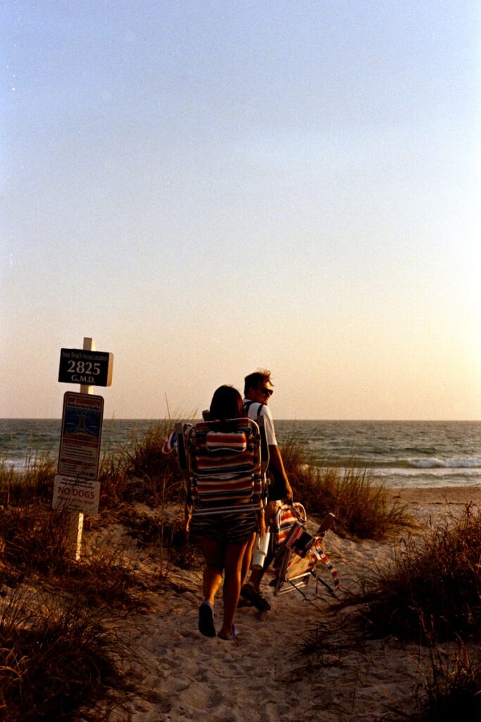 A couple of people walking down a dirt road